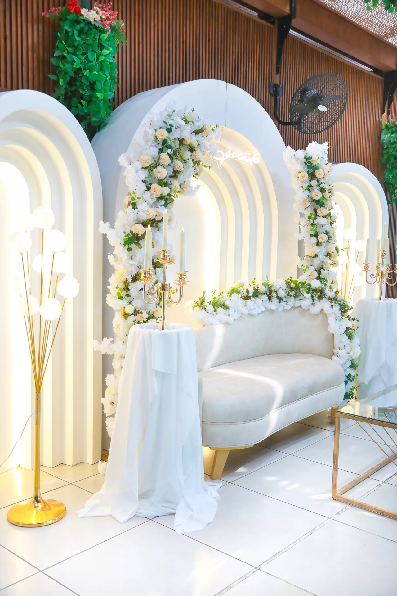 Bridal sofa framed by white floral arches